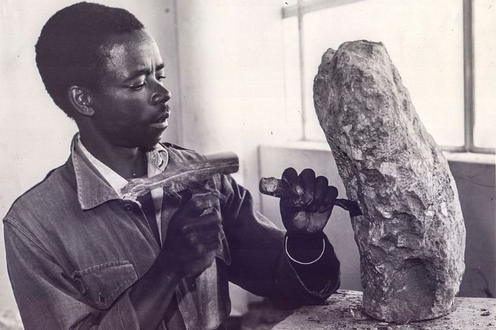 Zimbabwean sculptor Joseph Ndandarika chiseling a rock during the 1950s
