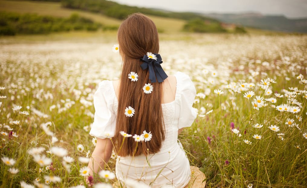 femme assise dans les fleurs cheveux
