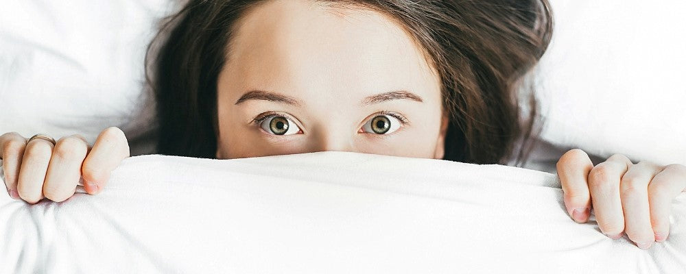 femme cachée sous la couette