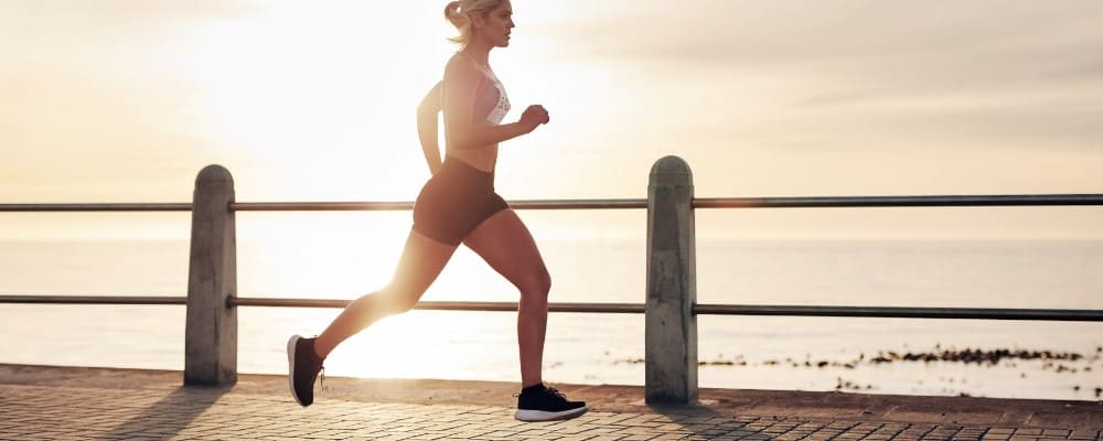 femme sportive qui court devant la mer