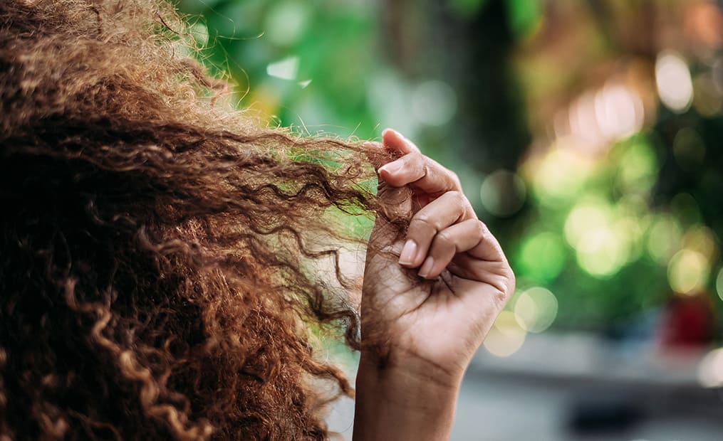 mains dans cheveux boucles femme