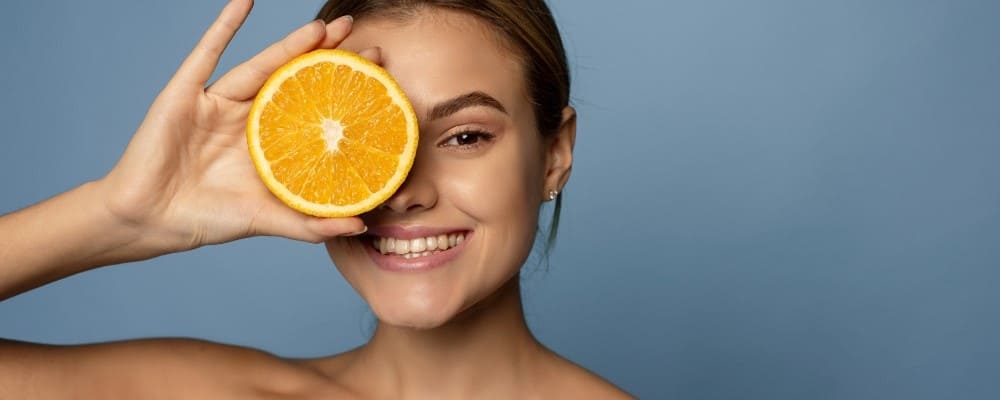 orange devant oeil femme souriante