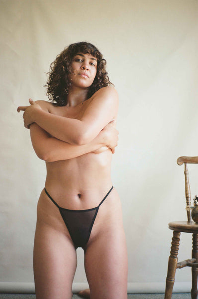 woman kneels in black underwear