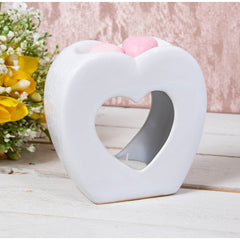 An image of a modern heart-shaped ceramic wax melt and oil burner, perfect for adding a chic aesthetic and wonderful scent to any room in your home. This burner is powered by a single tealight and doesn't require a plug-in, making it easy to place anywhere.