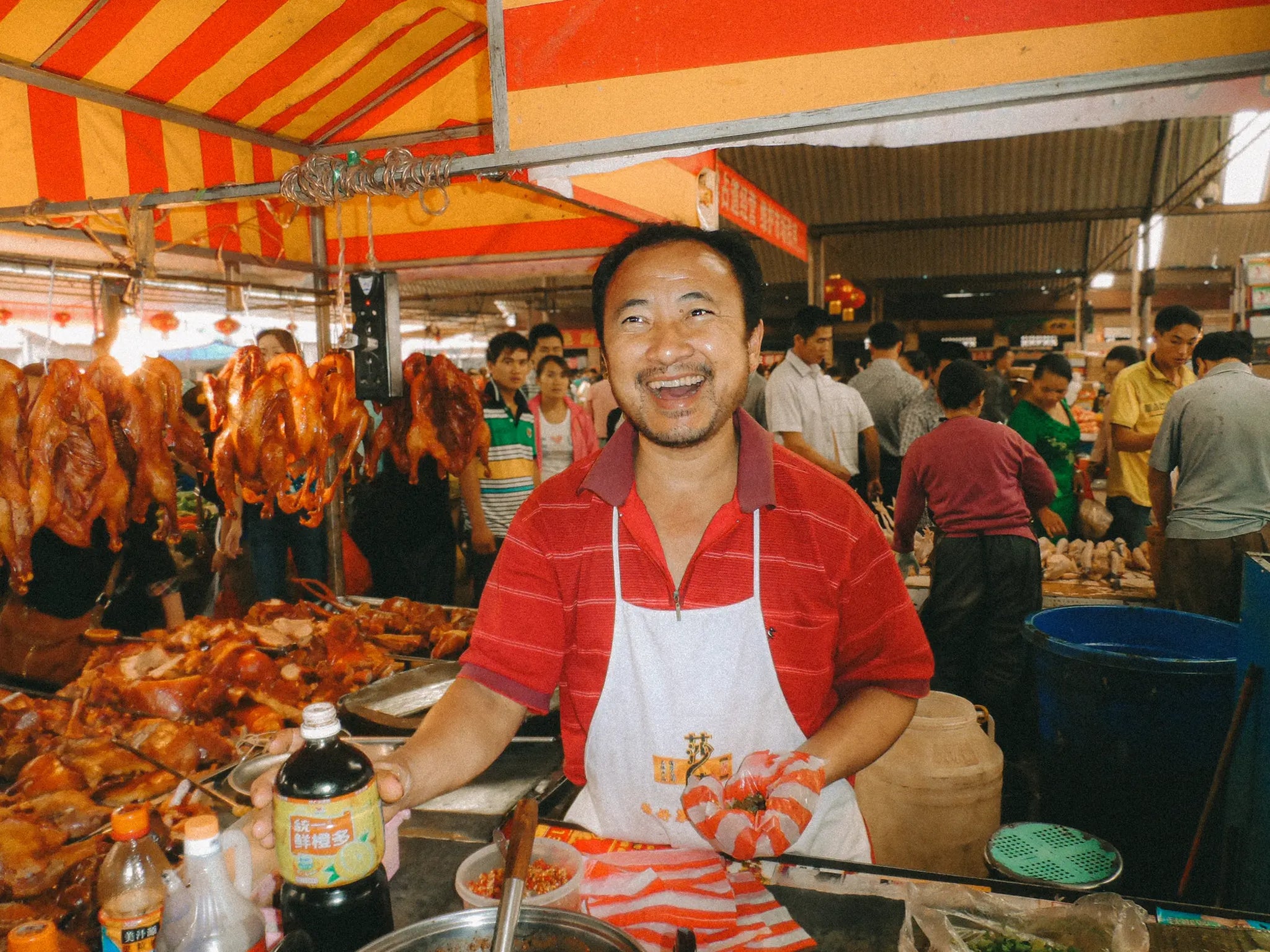 Man Smiling Stood at a Market Stall in Yunnan China
