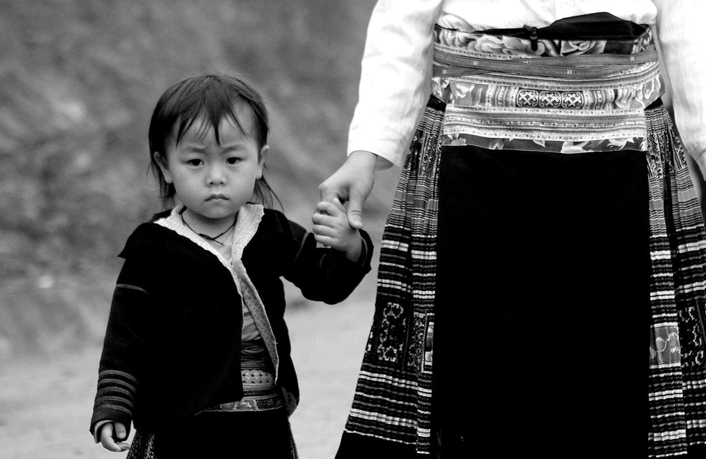 Child in the H'mong Tribe in Northern Vietnam holding hands with mother.