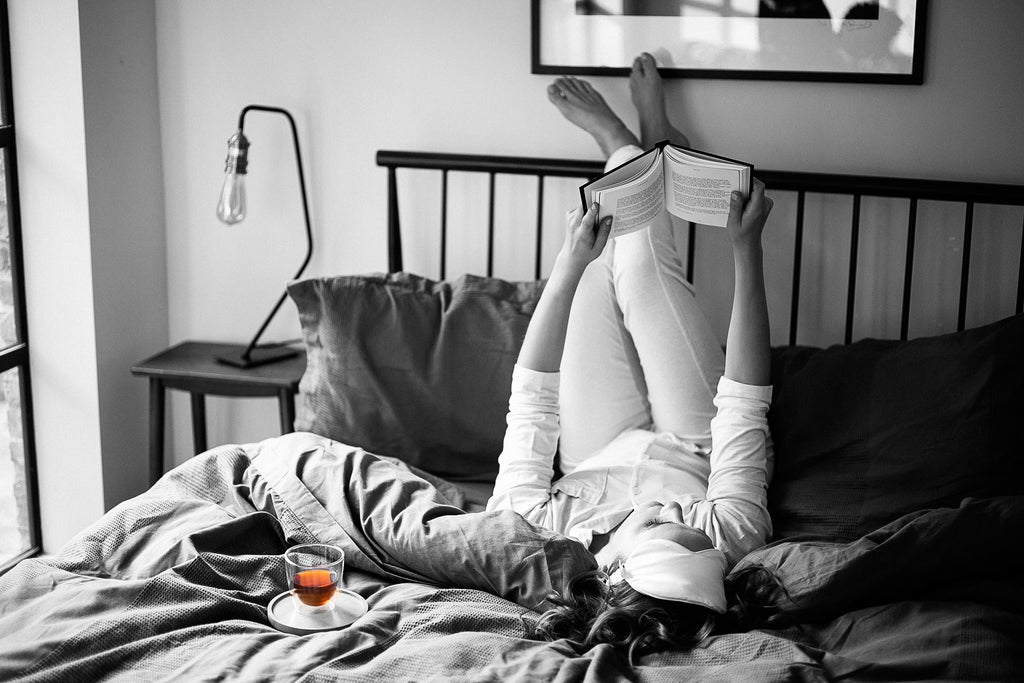 Woman laying in bed drinking Canton Tea