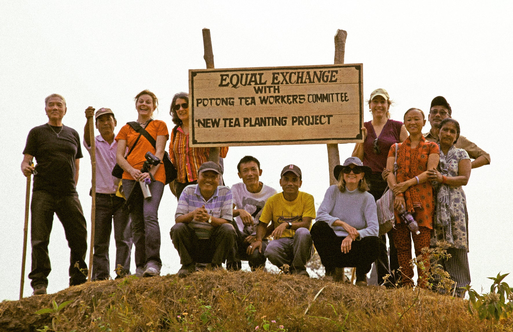 Members of a tea co-operative gathered around a sign