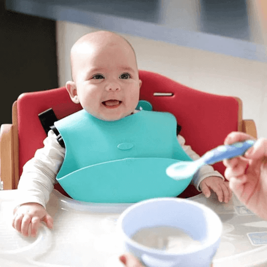 baby smiling and wearing ruby wrapp bib