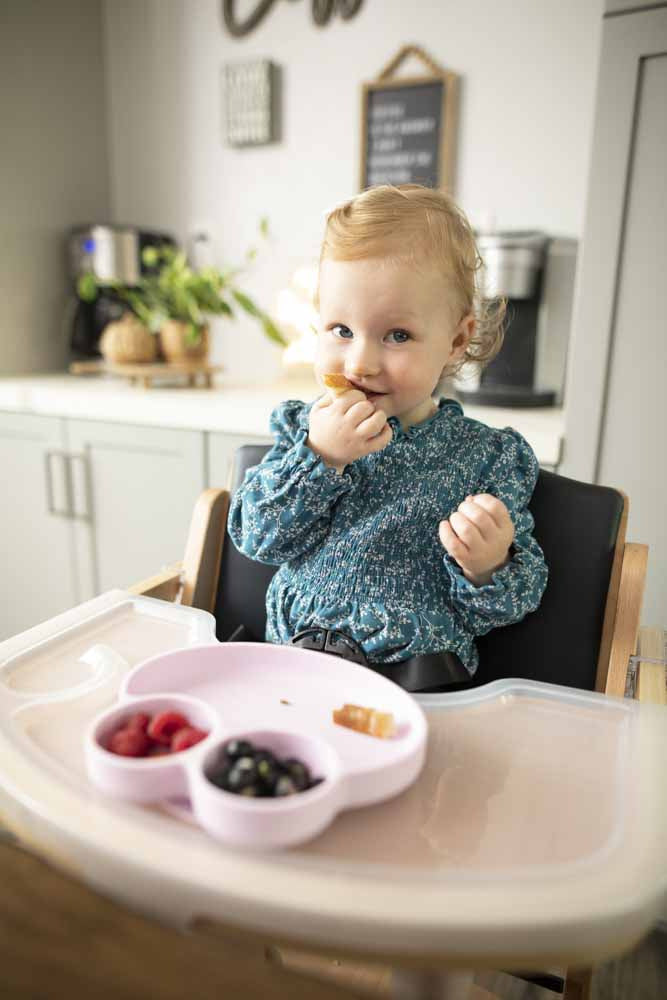 child eating snacks from Octopod® dish in Beyond Junior® high chair