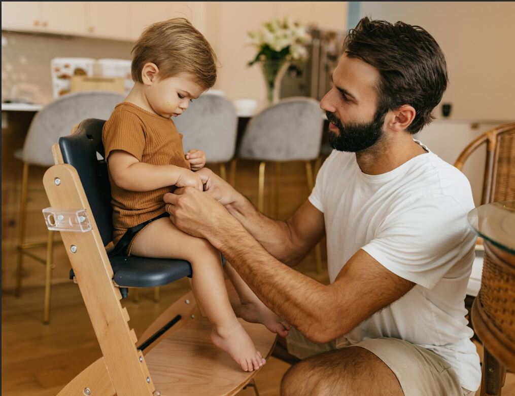 Dad strapping baby into Beyond Junior Y High Chair