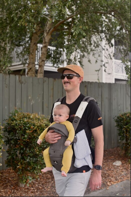 Dad walking with baby in Huggs Baby Carrier