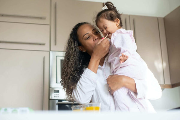 Woman holding and feeding a small child