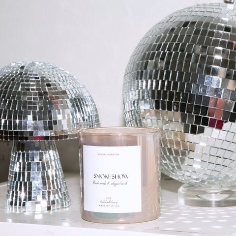 A Smokeshow candle in iridescent glass with two disco balls
