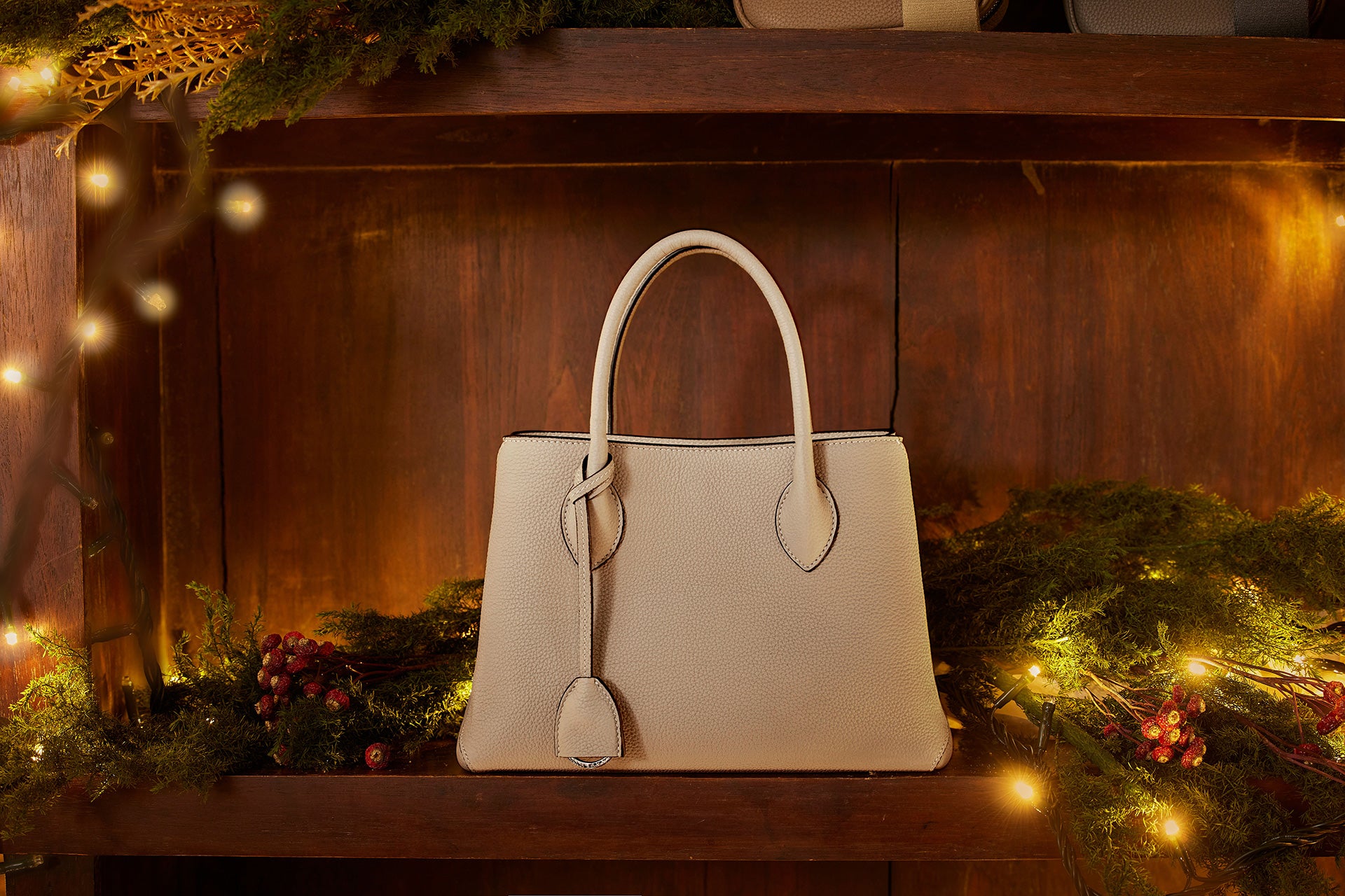 Tyylikäs BONAVENTURA-käsilaukku juhlallisesti koristellulla joulupöydällä.