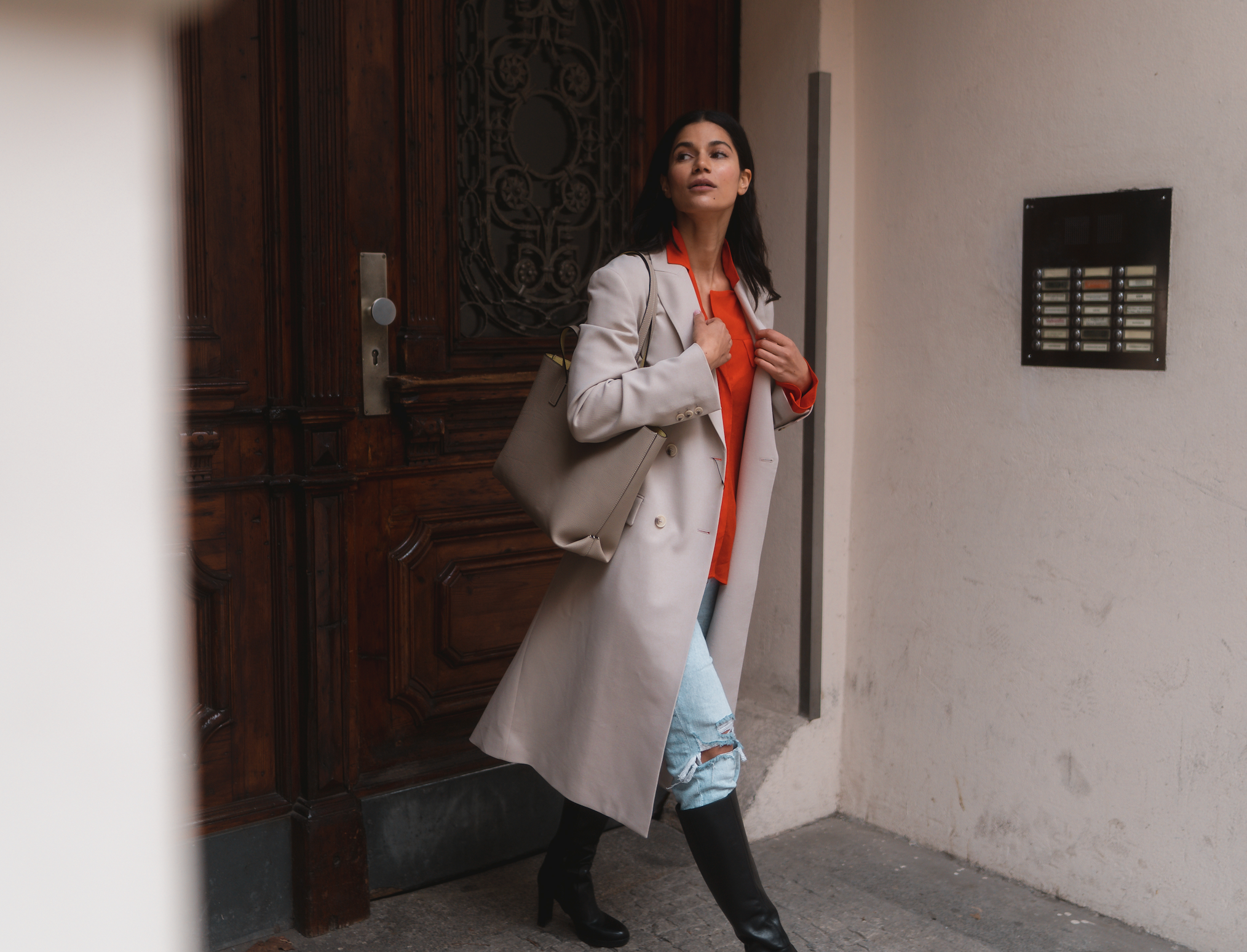 Une femme élégamment habillée avec son élégant sac à main en cuir BONAVENTURA dans les dernières couleurs tendance 2024.