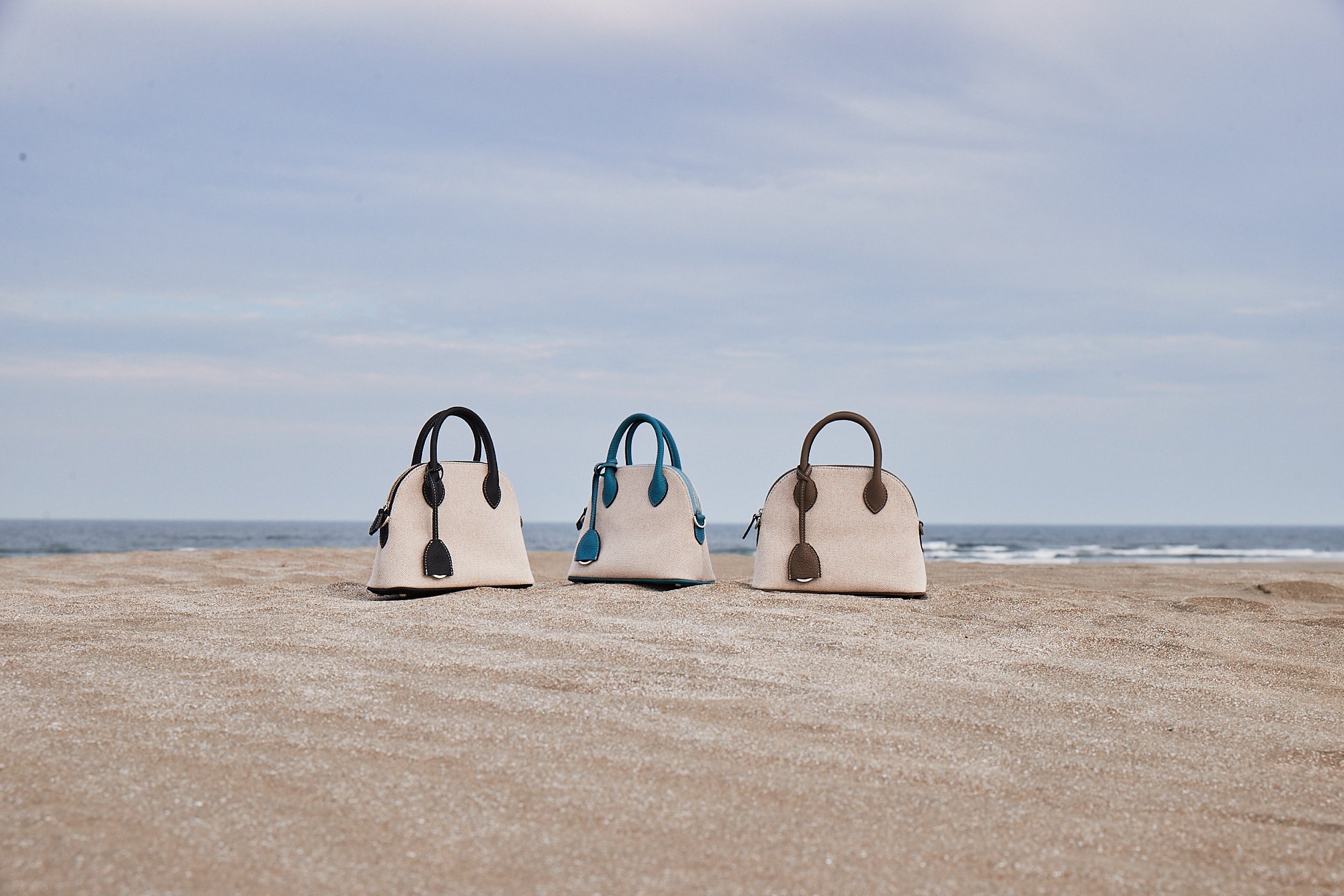 Letní plátěné tašky Mini Emma od BONAVENTURA představené na pláži.