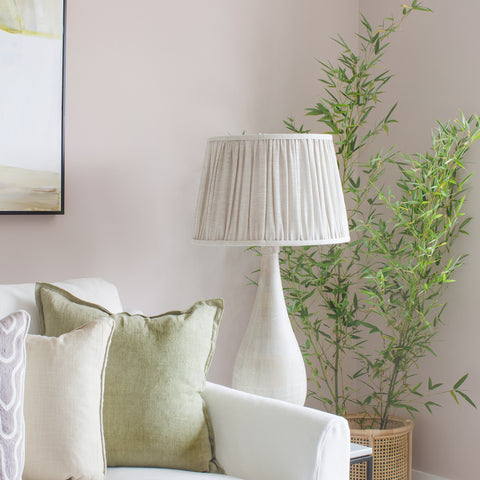 Neutral toned living room painted in Colourtrend Paints shade Lowland. Cream coloured couch, cream coloured lamp and lampshade, plant in the corner and picture on the wall.
