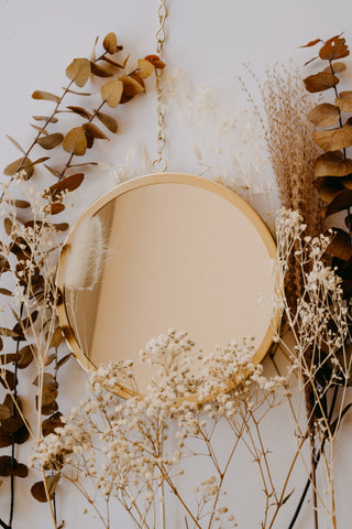 a brown round mirror with an aesthetic background