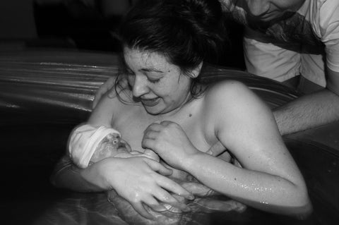New Mum cradling her newborn baby after water birth