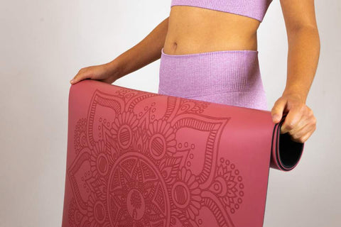 Aran tapis de yoga caoutchouc naturel - colori rouge rosé - déroulé par jeune femme yogi - my shop yoga