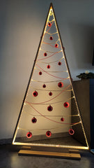 A minimalistic Christmas tree: a thin wooden triangle (mimics the shape of a christmas tree) with led lights lining the inside. There are red beads and red bulbs hanging from side to side.
