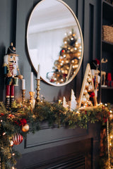 Traditional Christmas mantel with vintage nut crackers, garland, and gold accents.