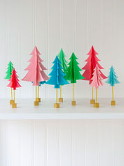 A cluster of vibrant and colourful DIY paper Christmas trees all lined up with gold holders.