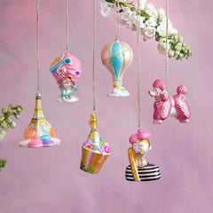 Pastel Christmas ornaments: the Eiffel tower with macaroons, an ice cream cone, a champagne bottle, hot hair balloon, poodle, and mime with a baguette. 