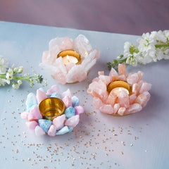 Three pastel crystal candle holders sitting on a baby blue table with gold sparkles.