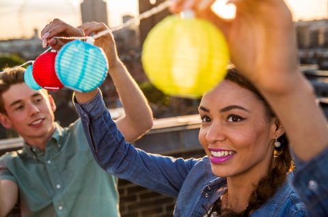 2 people hanging up mini lantern string lights