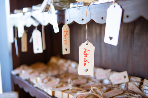 Name tags hang down from their respective party favours, each with a heart stamped through. The name "Adrian" can be see on one and on another, "Berru".