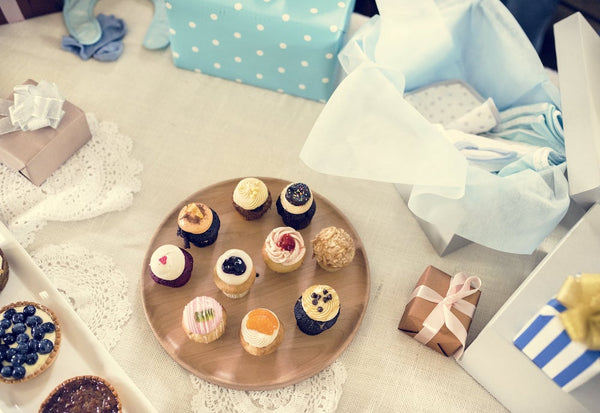 Cupcakes on a platter next to gifts and mini pies