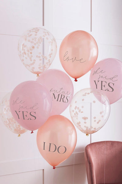 Pink and blush balloon bouquet that says "I do" and "She said Yes" messages on them