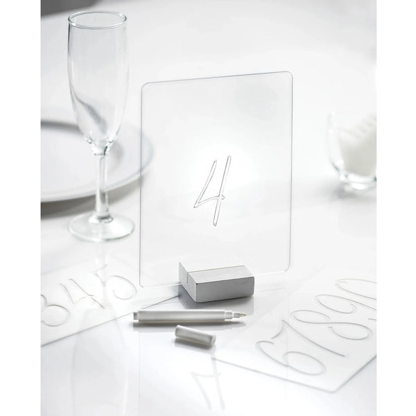 White and silver number 4 table sign on a white table with minimal decor 