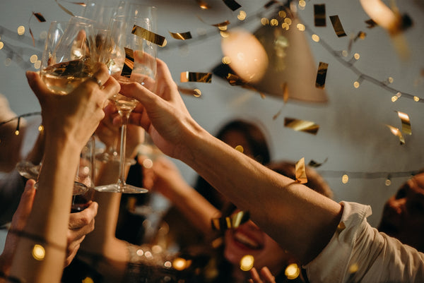 People celebrating a wedding shower: gold confetti falls as people cheers champagne 