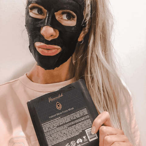 woman wearing a black face sheet mask