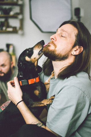 chien avec son maitre qui se fait lécher par son chien