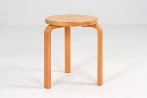 Stool 60 in wood finish by designer Alavar Aalto sits on a grey background