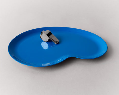 Marco Tray in swimming pool blue desinged by Revision holding a wistle on a grey background. 