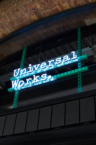 UNIVERSAL WORKS SCHRIFTZUG IN WEIßER NEONSCHRIFT