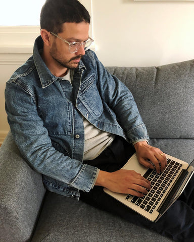 Karl von rogue territory sitz arbeitend an seinem apple macbook und trägt eine jeansblaue supply jacket