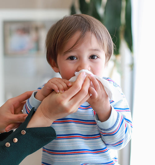 a child blowing his nose