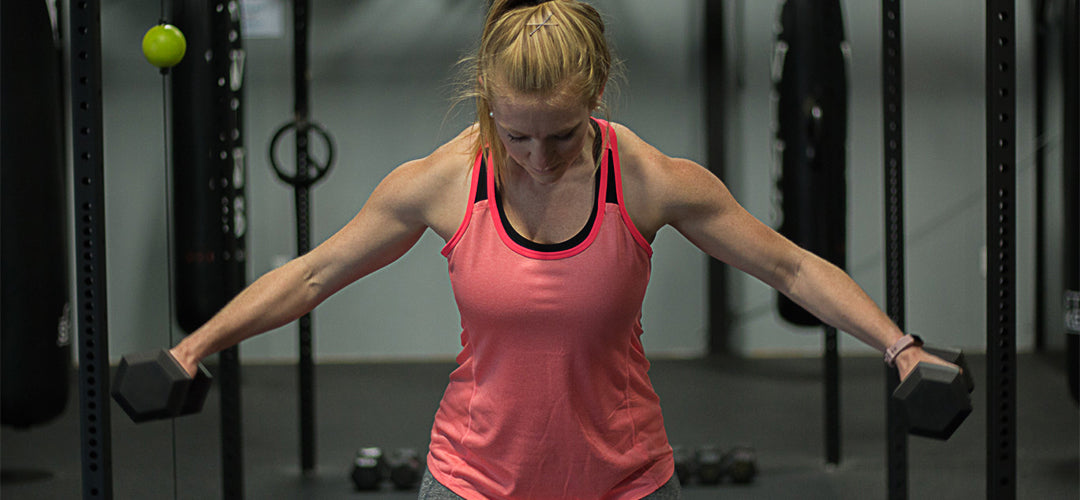 Woman working out with dumbbells in gym