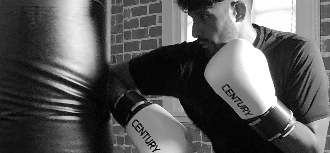 Man in white gloves hitting bag with his elbow