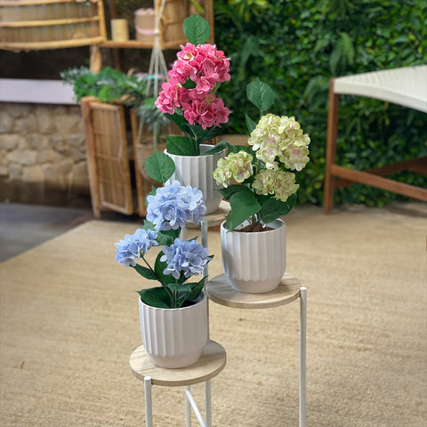 3 Artificial flower plants in pink, white and blue color in white pot