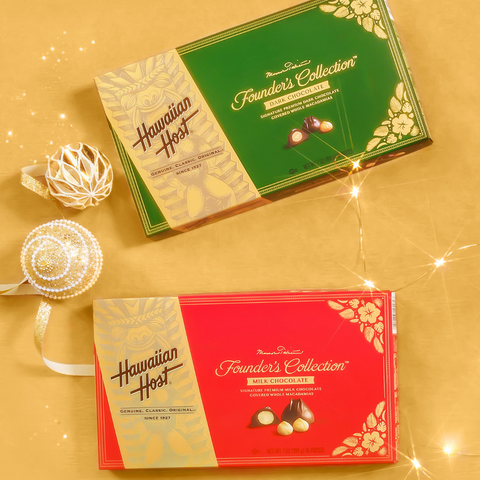 Hawaiian Host Founder's Collection Milk/Dark Chocolate gift box in Christmas Red and Green on gold sparkly holiday background with string lights and gold ornaments