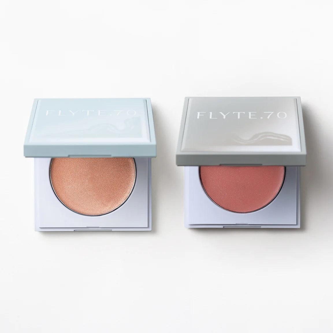 Compacts of complementary highlighter and cream blush in warm apricot and blushed rose