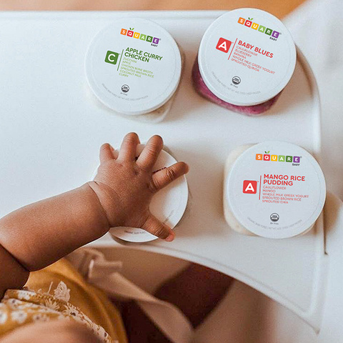 baby reaching for closed baby food jar