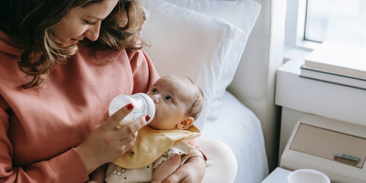 mum feeding baby with baby bottle